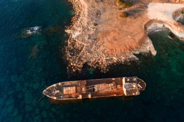 Deniz kıyısında alabora olmuş bir gemi var. Batık