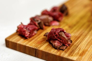 Tahta tepside dilimlenmiş et parçaları.