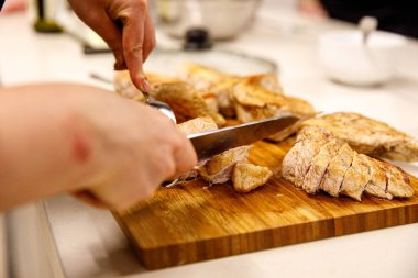 Şef hindi filetosunu kesiyor.