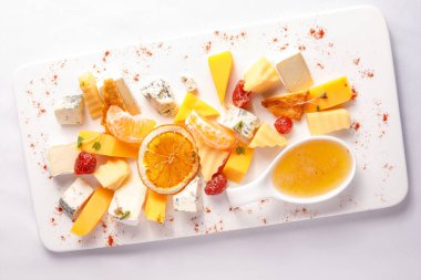 Portakallı peynir tabağı ve beyaz tabakta bal.