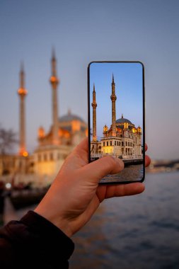Akıllı telefon kamerasıyla Ortakoy Camii 'nin fotoğraflarını çekmek. İstanbul, Türkiye