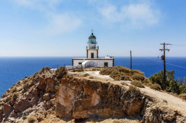 Kayalık deniz kıyısındaki eski deniz feneri. Bulutlu mavi gökyüzü