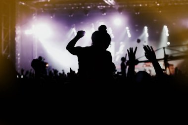 Müzik festivalinde kalabalığın içinde omuzlarında bir kız.