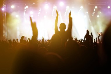 Müzik festivalinde kalabalığın içinde omuzlarında bir kız.