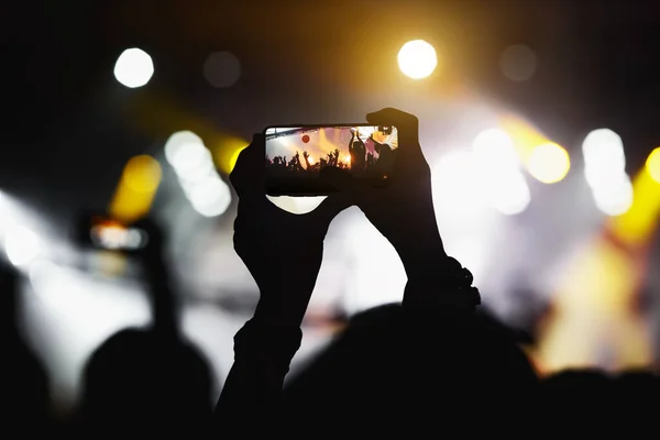 The fan taking a photo of a concert at a festival