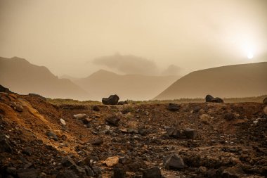 Volkanik manzara, gün batımında kum fırtınası..
