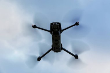 Gökyüzünde uçan katlanabilir bir dronun alt görüntüsü