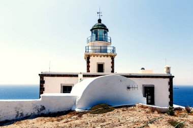 Kayalık deniz kıyısındaki eski deniz feneri. Bulutlu mavi gökyüzü