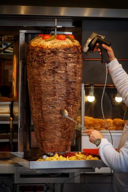 Geleneksel Türk yemeği Doner Kebap. Şef caddede ızgara rulo bifteği kesti.