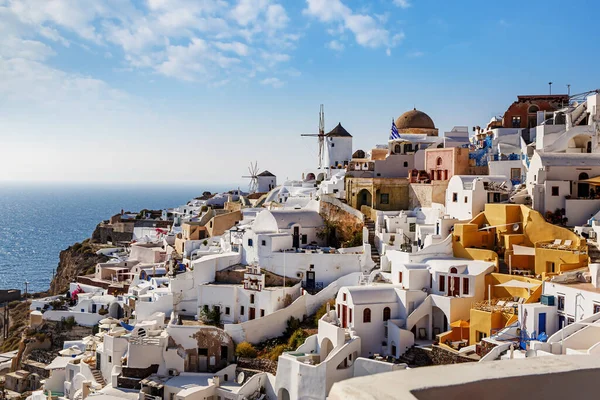 Santorini manzarası. Gün batımında Oia köyü. Mavi bulutlu gökyüzü altında beyaz binalar