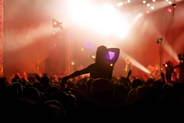 Men and women with raised hands at a concert event