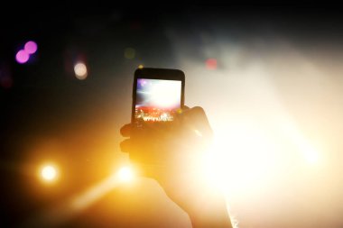 Fotoğraf çekmek ve konser müzik etkinliğinde video kaydetmek için akıllı telefonun soyut renkli arkaplanı, siyah siluet