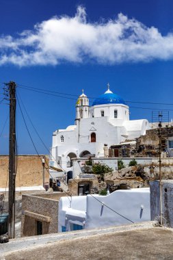 Yunanistan 'daki Santorini adasında mavi kubbeli beyaz bir kilise. Sıcak yaz güneşi günü