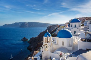 Santorini adasında tatil, Yunanistan 'a seyahat. Deniz ve kalderanın yanındaki beyaz kilisenin mavi kubbesi.