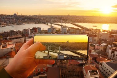 Günbatımında İstanbul, Türkiye. Cep telefonuyla şehrin fotoğrafını çekmek