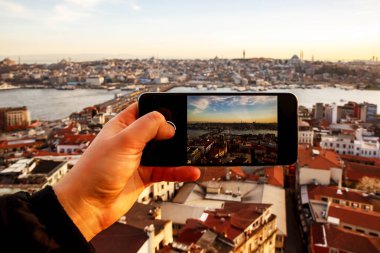 Günbatımında İstanbul, Türkiye. Cep telefonuyla şehrin fotoğrafını çekmek