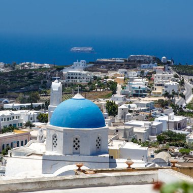 Yunanistan 'daki Santorini adasında mavi kubbeli beyaz bir kilise. Sıcak yaz güneşi günü