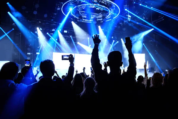 Happy crowd with raised hands at a rock concert