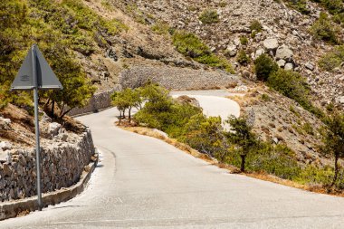 Santorini adasında dolambaçlı dağa tırmanma yolu