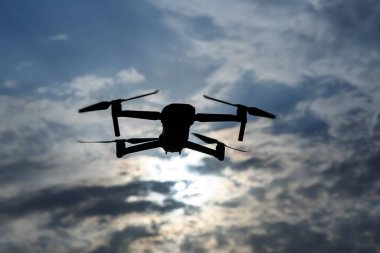 Gökyüzünde uçan katlanabilir bir dronun siyah silueti