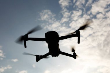 Gökyüzünde uçan katlanabilir bir dronun siyah silueti