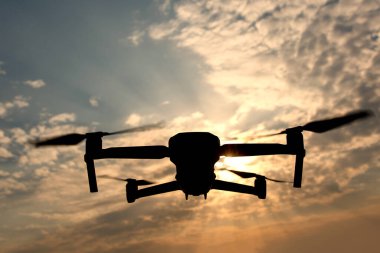 Gökyüzündeki dramatik bulutlara karşı bir dronun silueti