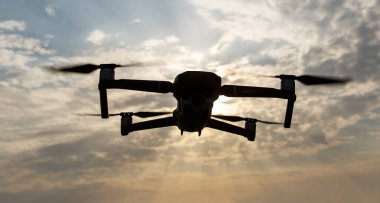 Gökyüzünde uçan katlanabilir bir dronun siyah silueti