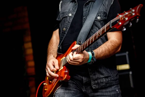Close-up of a guitar at a rock concert. The guitarist playing music on stage