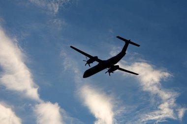 Yerden uçağın göbeğine kadar uzanan geniş, modern bir uçak gökyüzünde uçar.