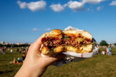 Açık hava yemek festivalinde hamburger yemek..