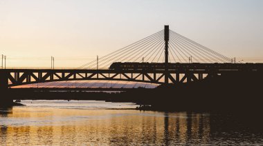 Nehrin üzerindeki demiryolu köprüsünde trafik vardı. Gün batımında tren