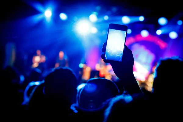 Photo for social network at concert. Mobile phone on music show