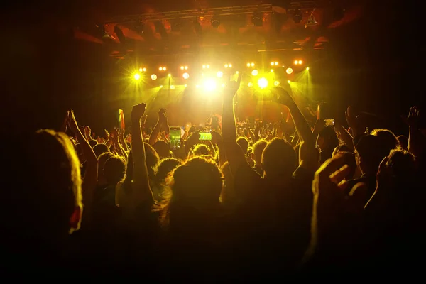 コンサートに出席するコンサートの群集 舞台照明に照らされたシルエット — ストック写真