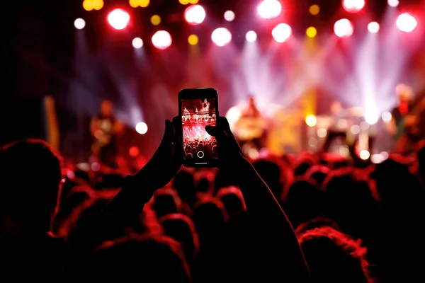 Streaming a music concert to social media via smartphone.