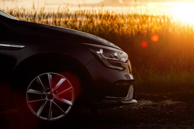 Günbatımında modern bir arabanın farları