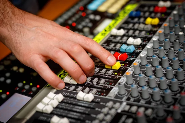 Hand of a sound manager on sound console mixer. Equalizer control