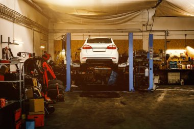 Car raised on car lift at auto repair service.