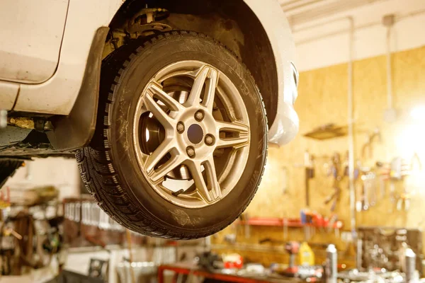 Close-up car wheel on a lift in a car service