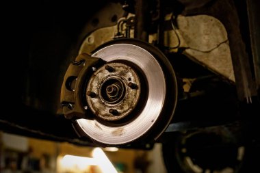 Disc and brake caliper of the vehicle for repair in the garage.