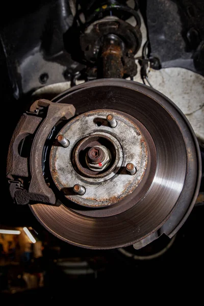 Disc and brake caliper of the vehicle for repair in the garage.