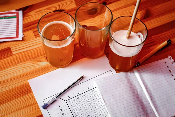 The pub quiz concept. Beer glass and blank paper for answers