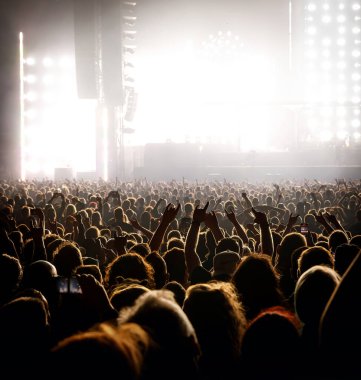 People with raised hands at a music concert. Fans in a concert hall