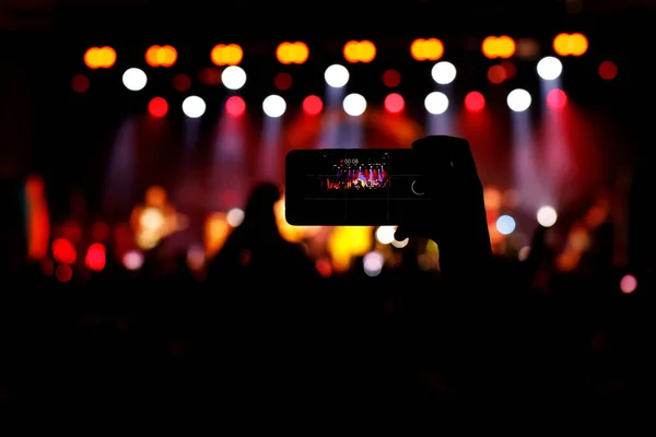 Taking photos of the concert stage, live concert, and music festival due to mobile phone