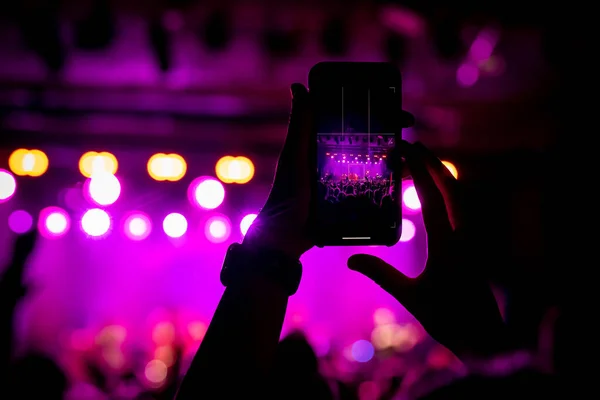 Taking photos of the concert stage, live concert, and music festival due to mobile phone