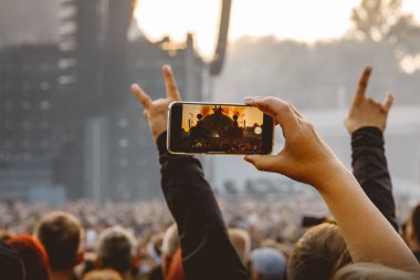Smartphone in the hand of a music fan at the summer concert