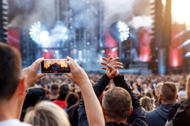 Crowd, happy people enjoying a rock concert, raised up hands and clapping with pleasure