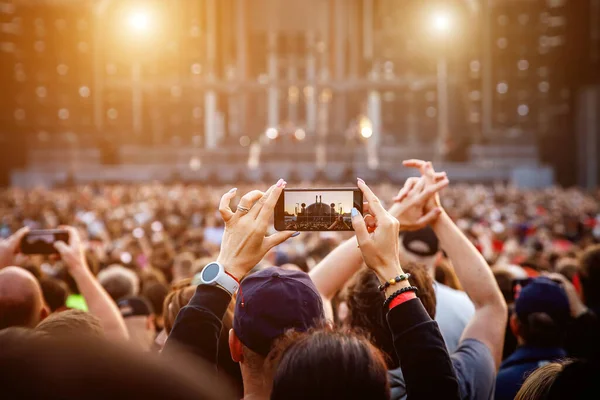Smartphone in the hand of a music fan at the summer concert