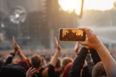 Smartphone in the hand of a music fan at the summer concert