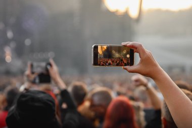 Smartphone in the hand of a music fan at the summer concert