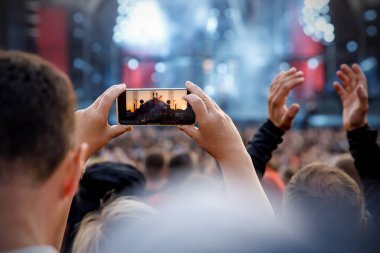 Recording a concert using a mobile phone. Smartphone at music show